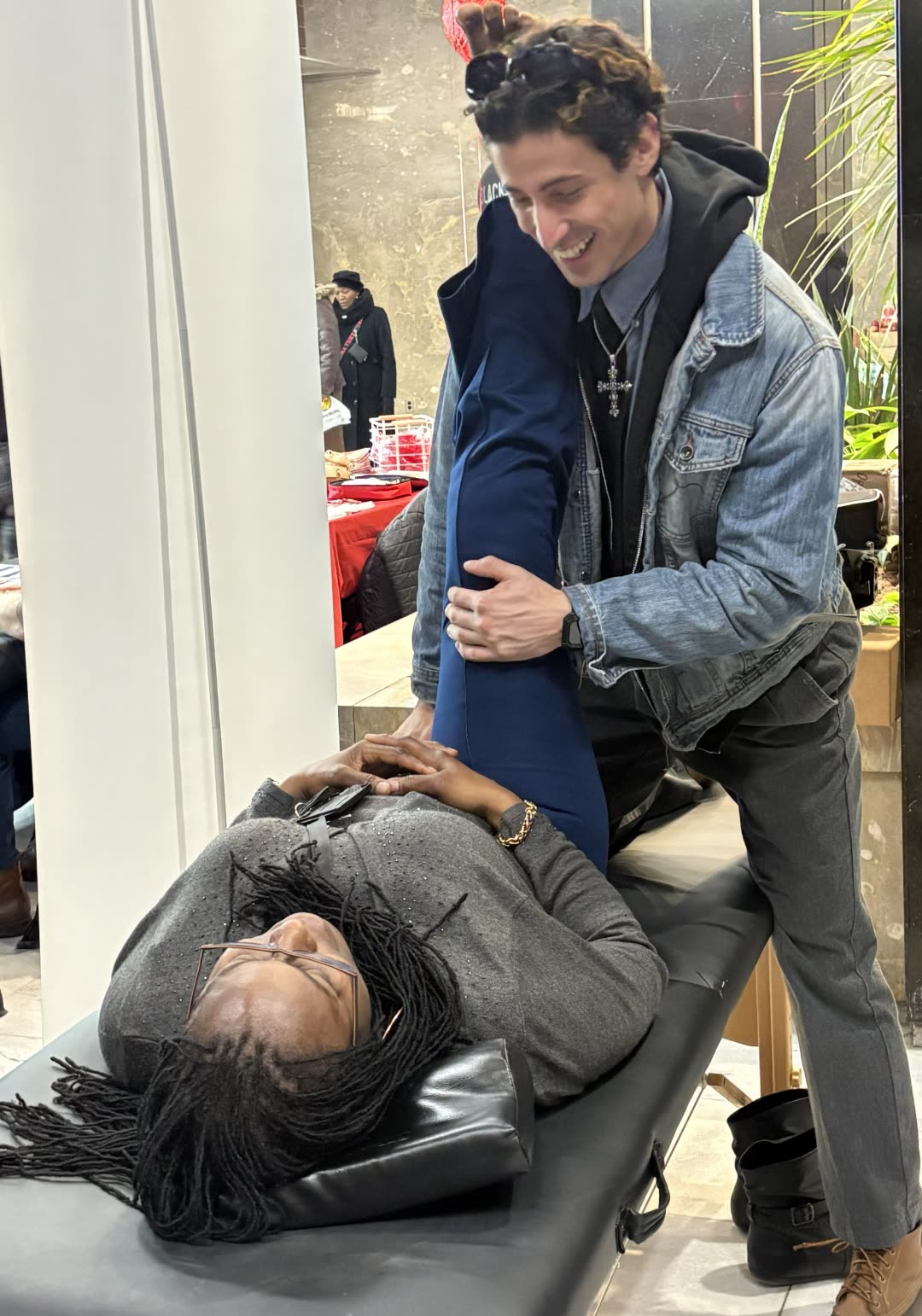 Matthew Jenkins, founder of Stretch RVA, smiling while guiding a client through an assisted stretch.