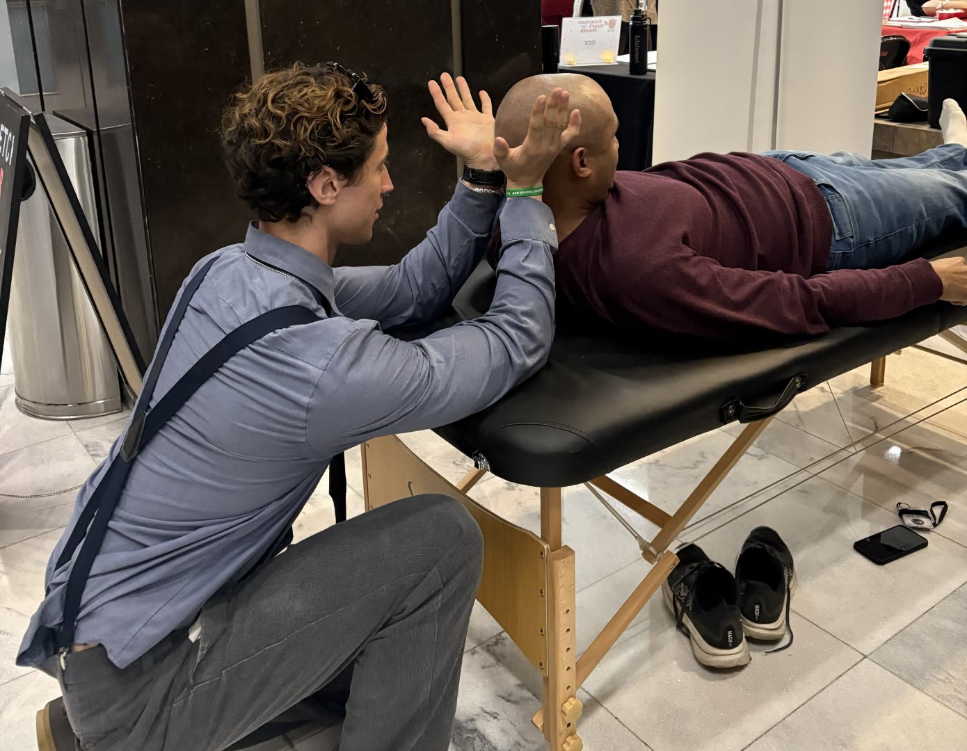 Matthew Jenkins guiding a client through an assisted upper-body stretch.